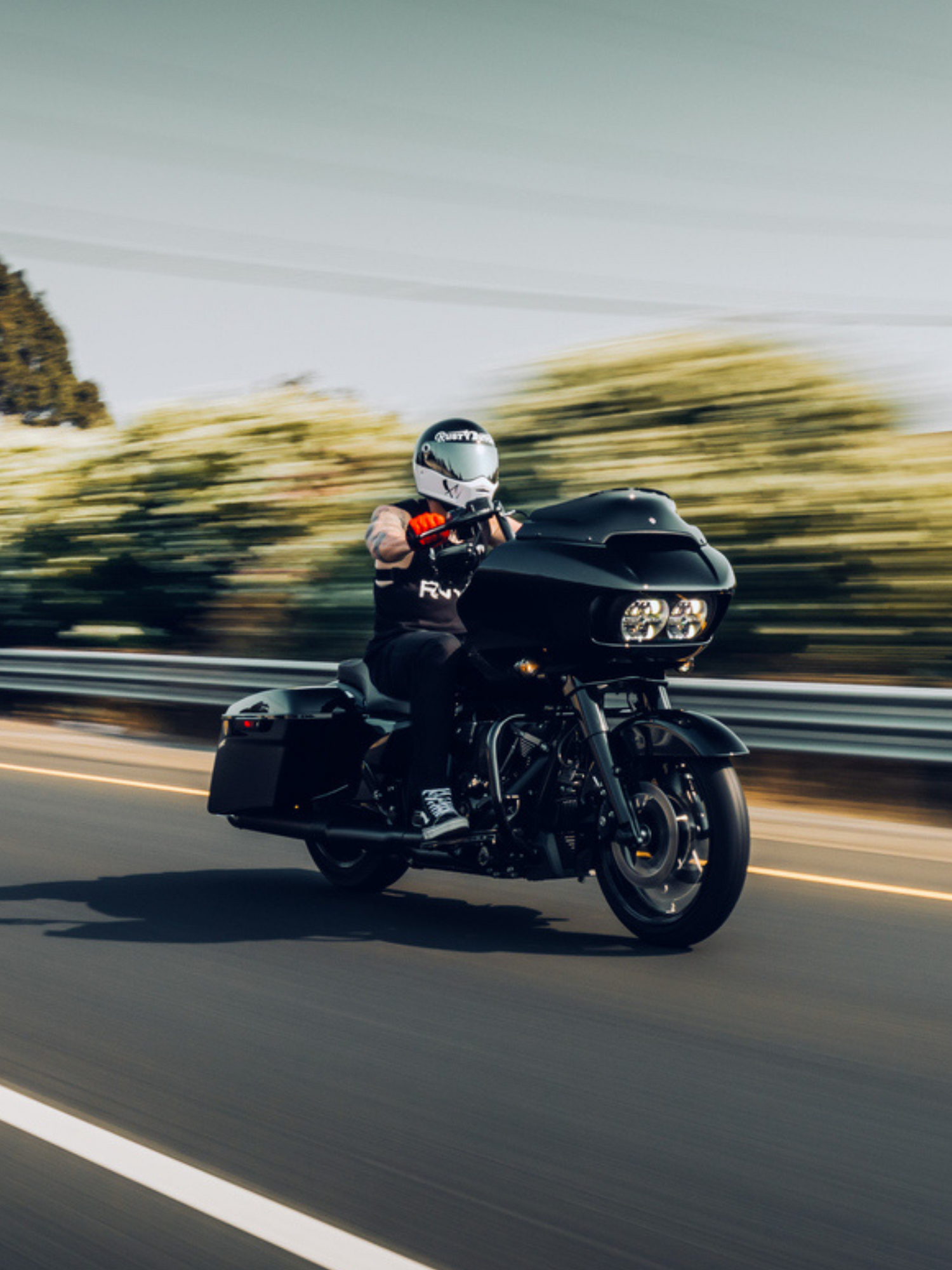 man riding a black motorcycle on a highway