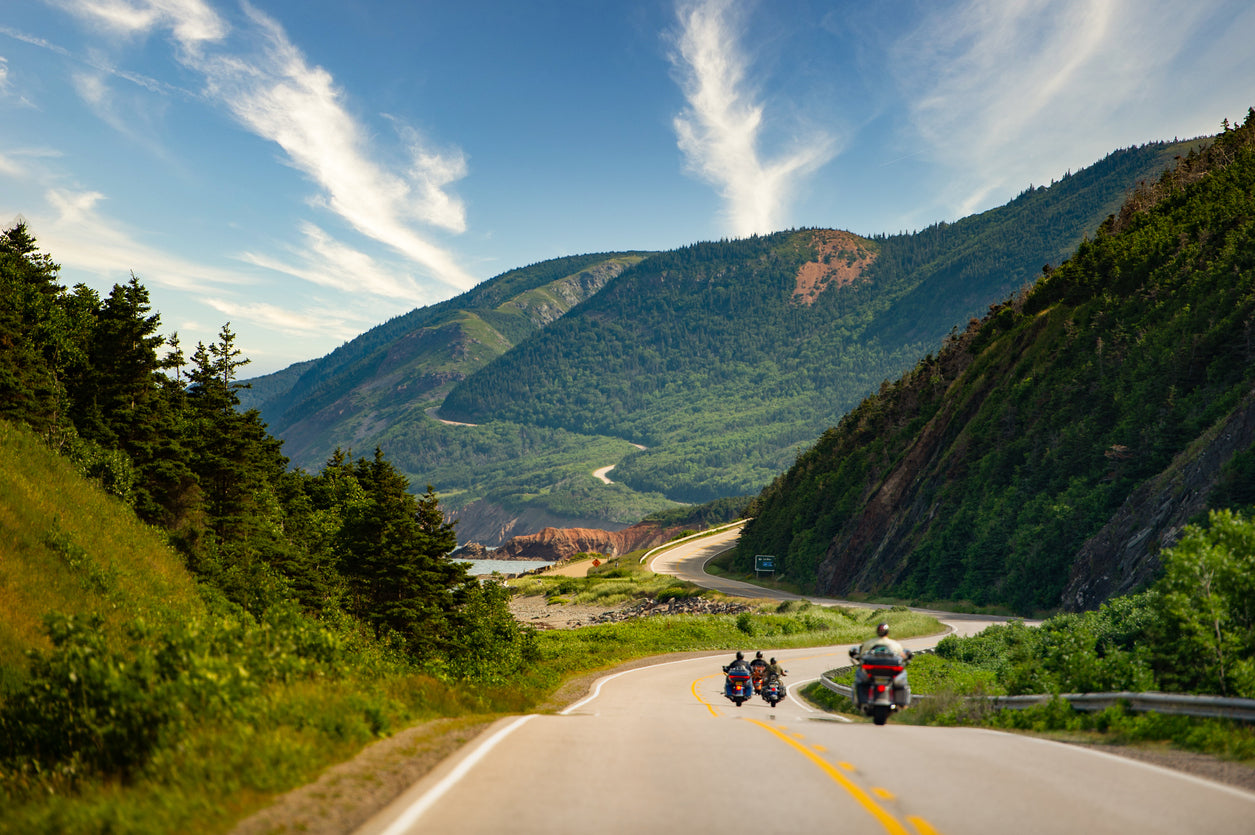 group of motorcycles riding down a mountain road