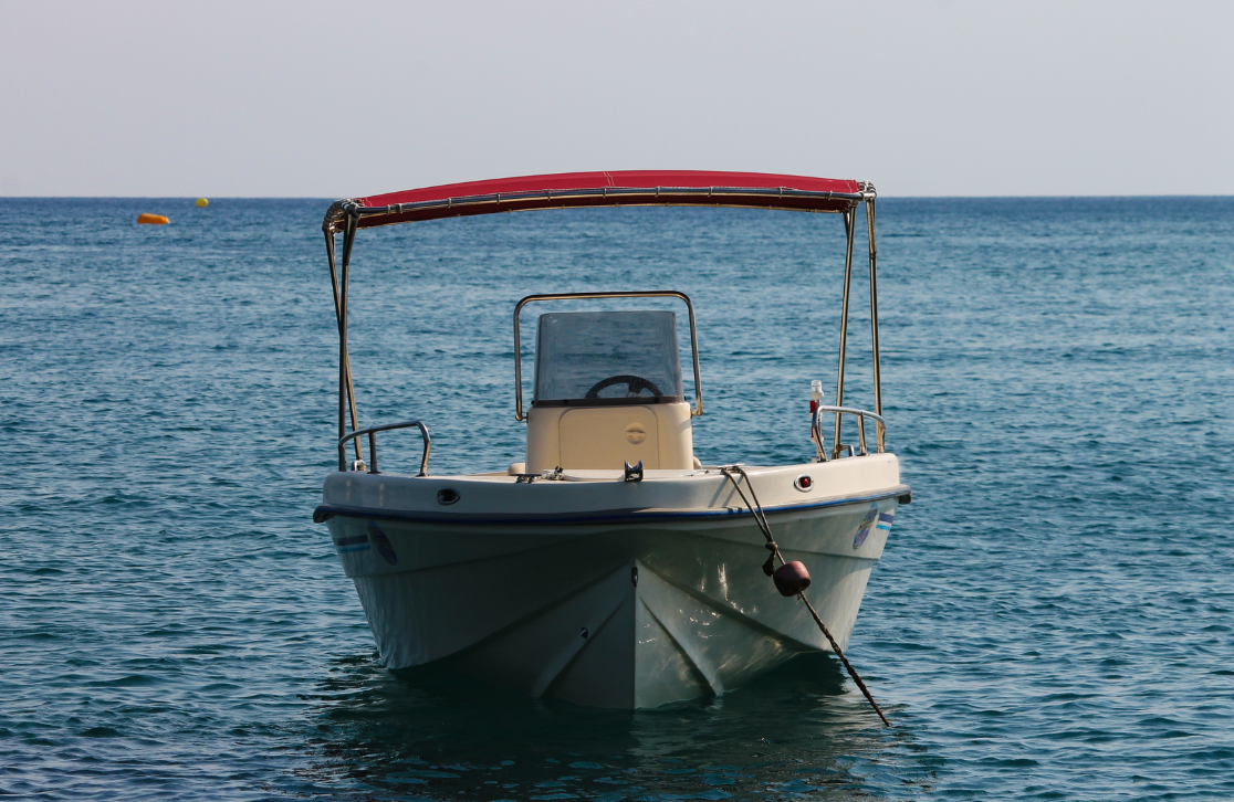 white boat with red top anchored in the ocean