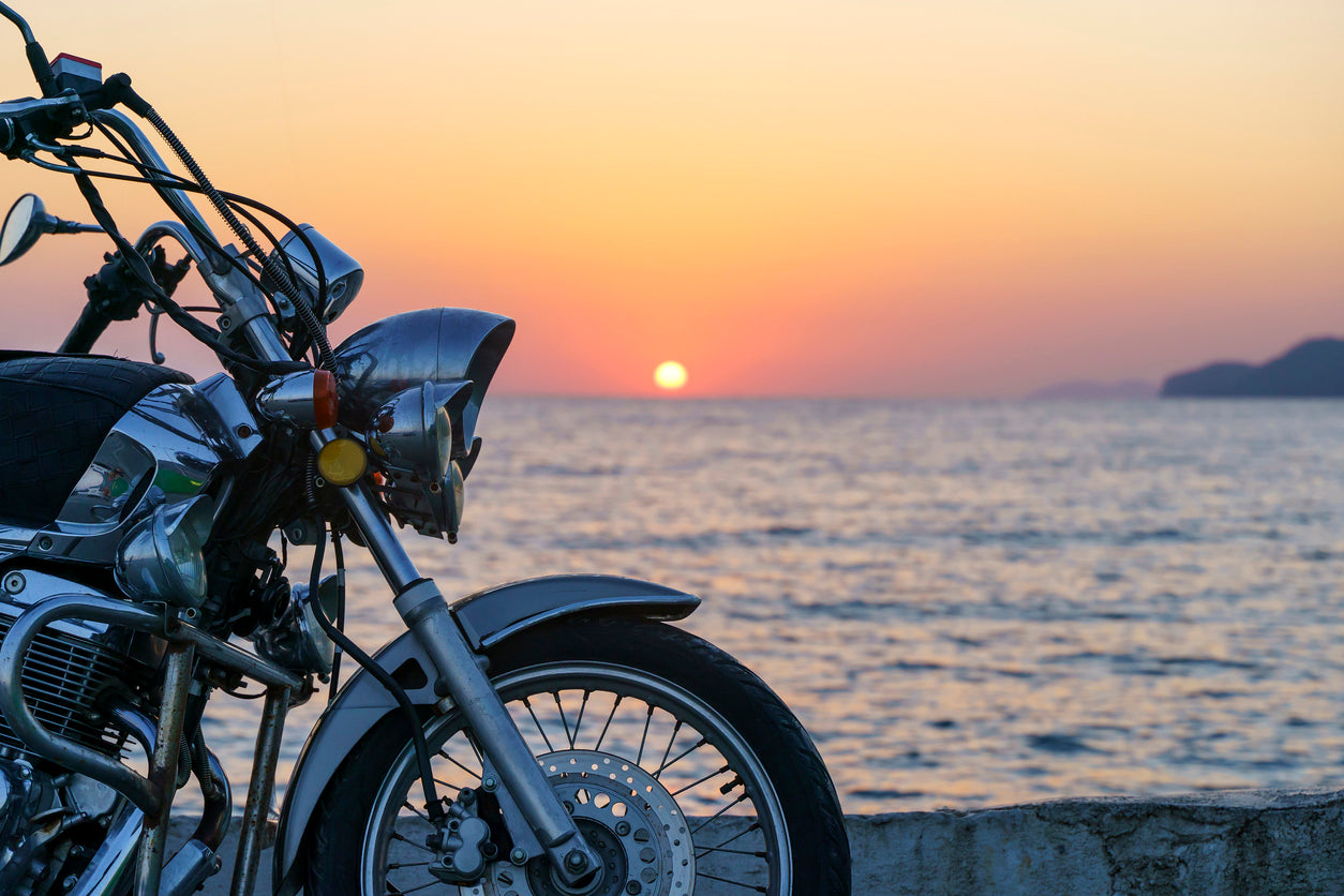 motorcycle parked in front of a sunset