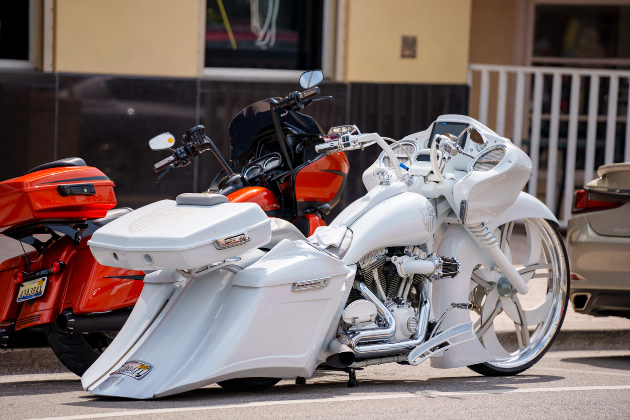 white and orange motorcycles parked on the side of street together 