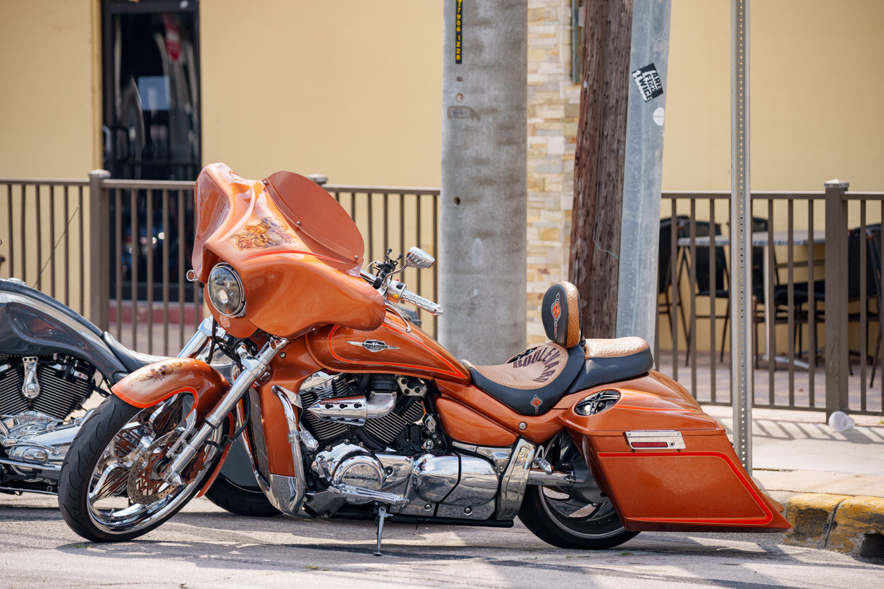 orange motorcycle parked on street corner